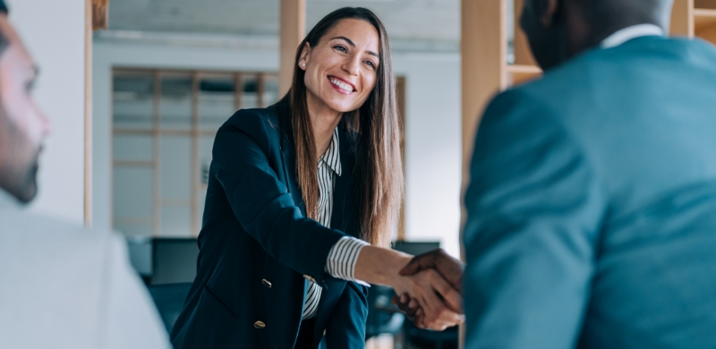 Businesswomen exchanging a handshake during a professional meeting.