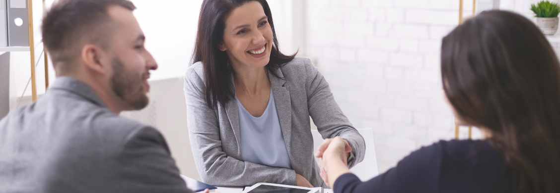 In an office setting, a woman and a man shake hands, signifying the collaboration for business solutions.