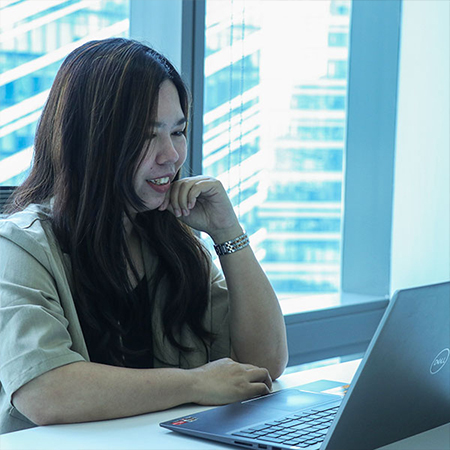 A woman sitting at a desk with a laptop, engaged in business process outsourcing.