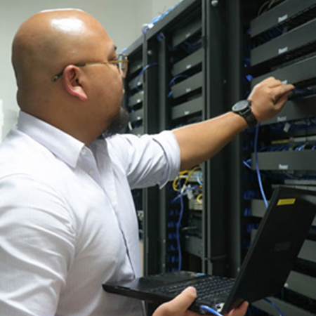 IT support specialist in sharp corporate attire, skillfully repairing cable wires to ensure a robust and dependable network infrastructure in the professional workplace.