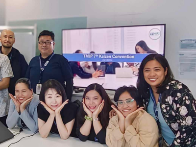Team photo in front of a computer screen at a BPO company in BGC Taguig.