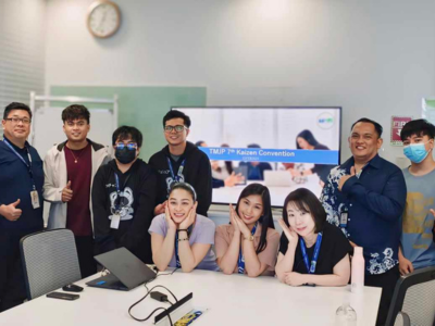 Group photo in front of a screen, celebrating Kaizen innovation at a BPO company in BGC Taguig.