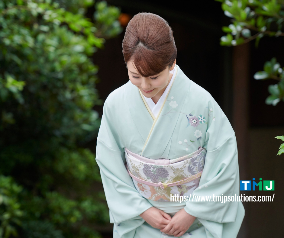 A woman wearing a kimono bowing courteously to represent Japanese omotenashi