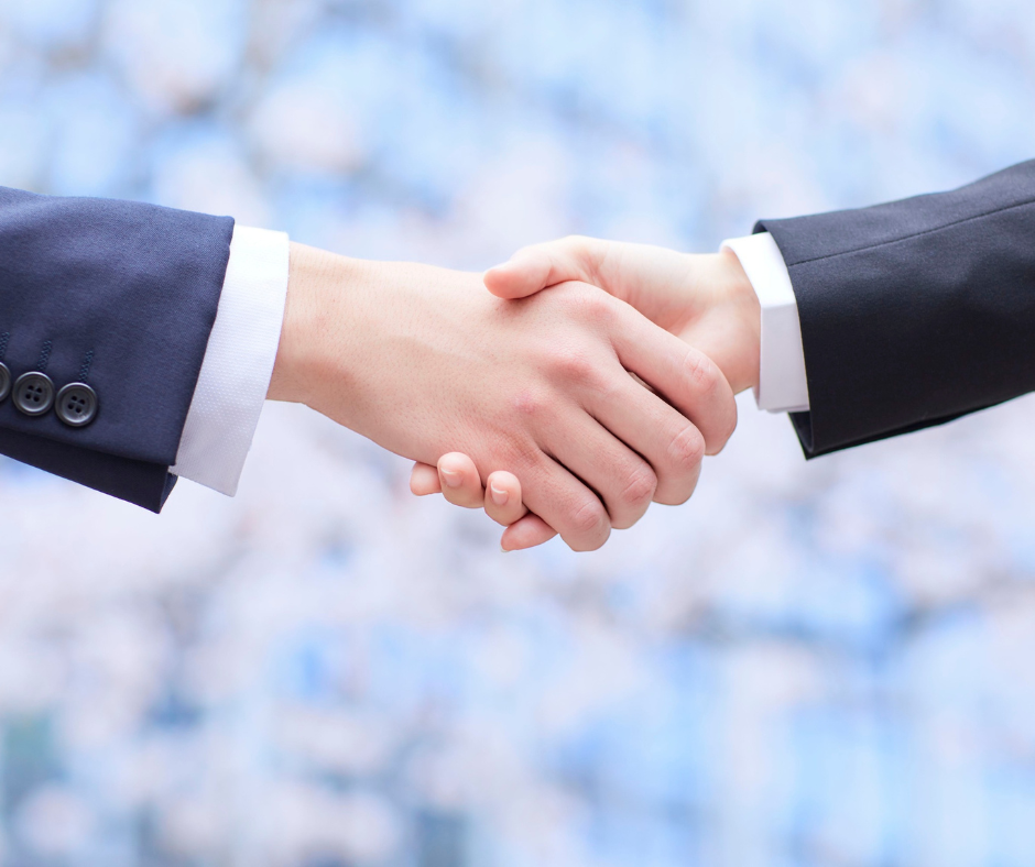 Two business professionals shaking hands, symbolizing partnership and global collaboration.