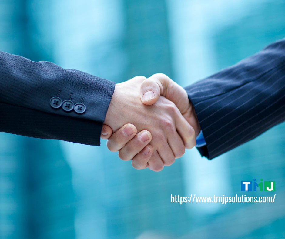 Two professionals in business suits shaking hands, symbolizing BPOs bridging language and cultural gaps through collaboration and trust.