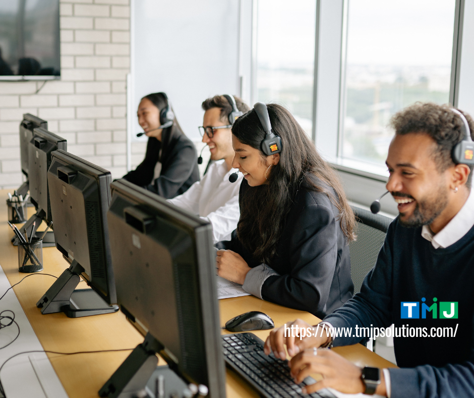 Customer support team wearing headsets at a modern office desk, symbolizing outsourcing strategies for globally expanding SMEs in 2026.