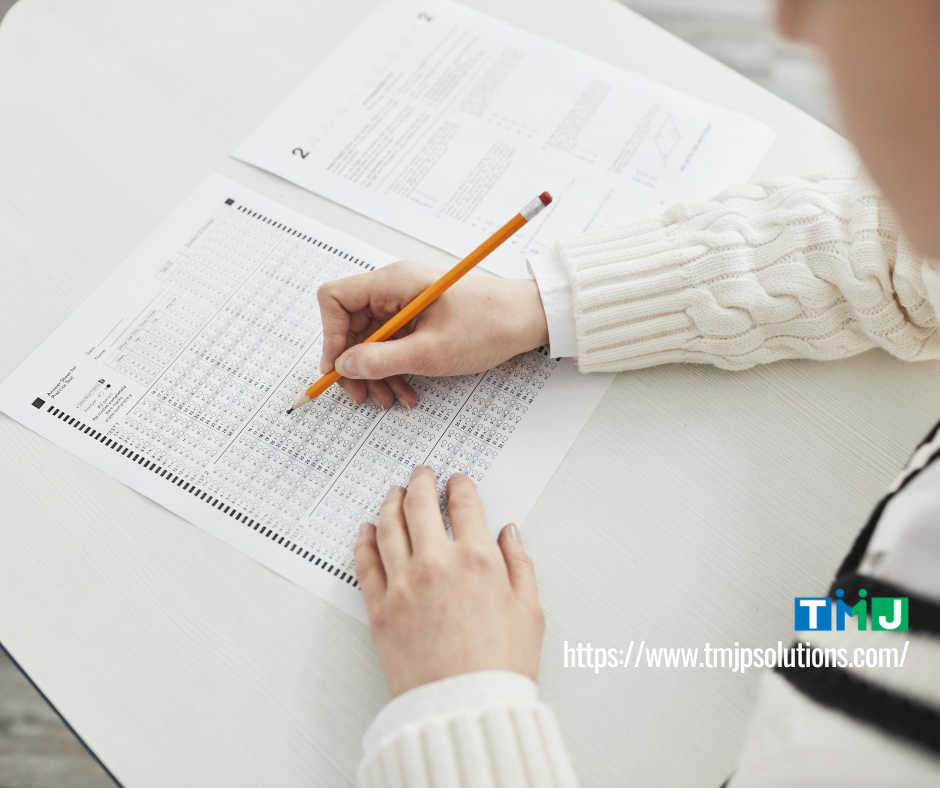 Student filling out a standardized test answer sheet with a pencil, symbolizing fresh graduates pursuing English proficiency certifications.